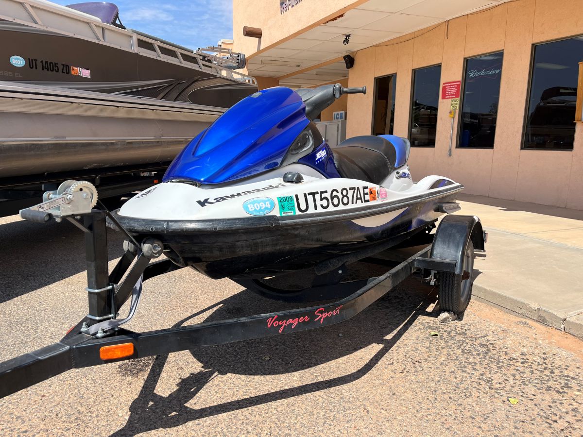 Blue and white Kawasaki jet ski on trailer parked near marina facilities at Lake Powell in Glen Canyon National Recreation Area, Utah.